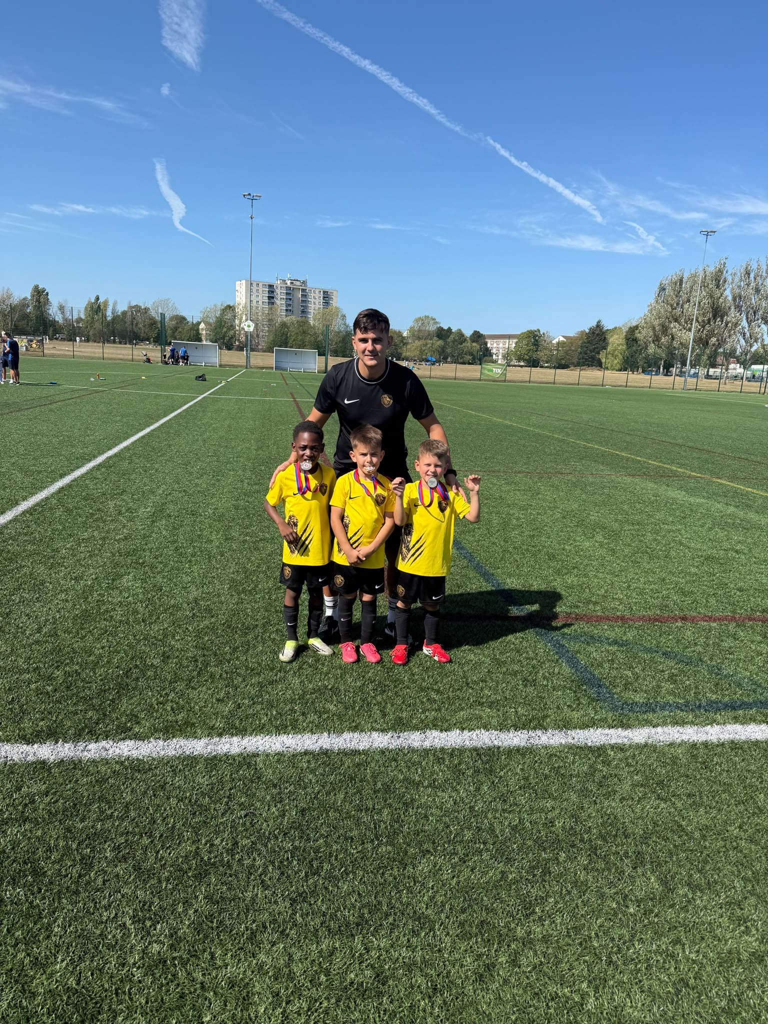 Coach with players showing off their medals
