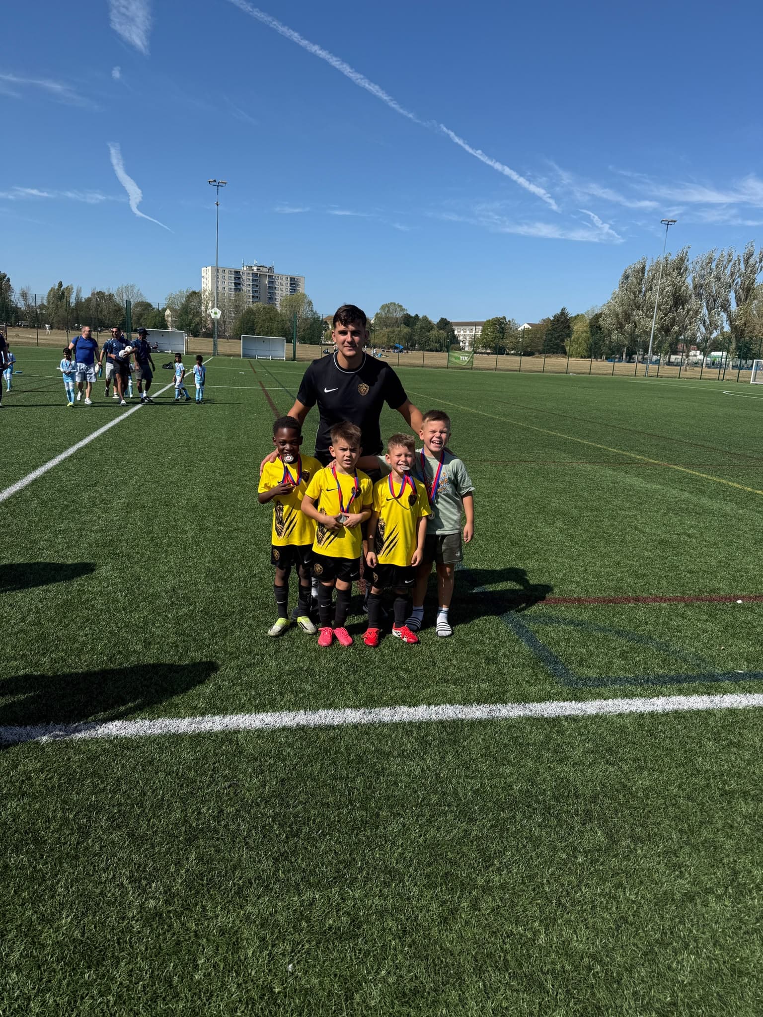 Coach with players showing off their medals